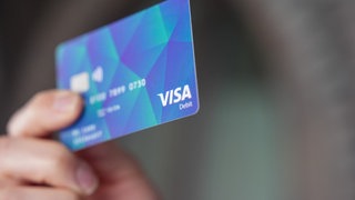 Ein Mann hält eine Bezahlkarte für Geflüchtete in der Hand.