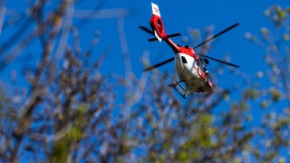 Ein Rettungshubschrauber fliegt über einen Wald. Am Donnerstagnachmittag ist ein Mann bei einem Drachenflug tödlich verunglückt. Die Unfallursache ist derzeit noch unklar.