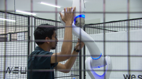 Ein Mitarbeiter arbeitet an einem Roboter