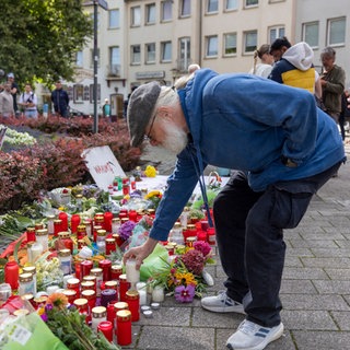 Nach dem Messeranschlag auf dem Stadtfest in Solingen stellt Philipp Müller, Hauptorganisator der Jubiläums-Feier, im Gedenken an die Opfer eine Kerze auf.