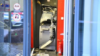 Ein gesprengter Geldautomat ist in einem Bankgebäude zu sehen.