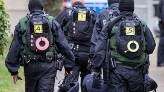 Beamte der Bundespolizei gehen im Rahmen einer Razzia durch ein Wohngebiet (Archivbild).