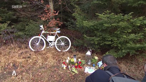 Gedenkort für verstorbenen Radfahrer mit Blumen und Fahrrad