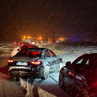 Autos stauen sich im Schneetreiben und bei Glätte auf der B312 im Landkreis Biberach. Nach Angaben des Deutschen Wetterdienstes werden vor allem die Hochlagen des Landes von weiteren Schneefällen betroffen sein.
