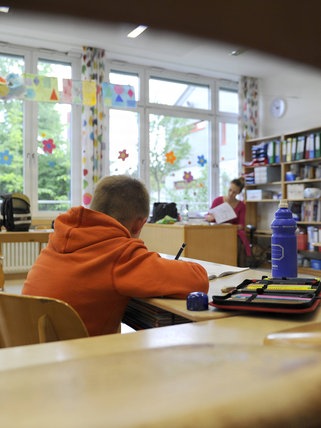 Schülerinnen und Schüler bei einem Test in einem Klassenzimmer einer Grundschule.