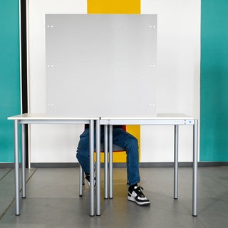 Symbolbild - Eine Person gibt im Wahllokal ihre Stimme ab