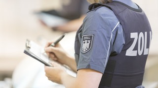 Sujetbild: Eine Zollbeamtin dokumentiert auf einem Klemmbrett. In Deutschland gibt es einer aktuelln Studie zufolge immer mehr Schwarzarbeit. 