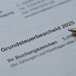 Ein schwarze Kugelschreiber liegt auf dem Grundsteuerbescheid für das neue Jahr 2025.