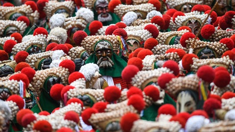 Narren der Elzacher Schuttig laufen beim traditionellen Schuttigsprung durch die Hauptstraße.