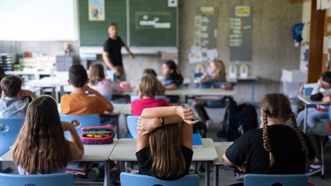 Schülerinnen und Schüler einer Grundschulte nehmen am Unterricht teil.