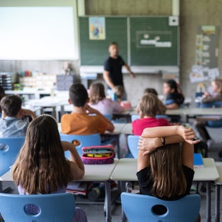Schülerinnen und Schüler einer Grundschulte nehmen am Unterricht teil.