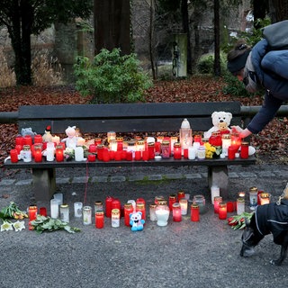 Eine Frau stellt eine Trauerkerze neben Blumen nach dem tödlichen Angriff in Aschaffenburg ab. Nach der Messerattacke gibt es auch in Baden-Württemberg Debatte um die Sicherheit im Land.