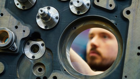Ein Mitarbeiter montiert im Stammwerk der Heidelberger Druckmaschinen AG das Seitenteil eines Druckwerks.
