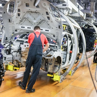 Ein Monteur arbeitet an einem Fahrzeug. Auch die Autoindustrie ist von Gewinneinbruch und Stellenabbau betroffen. Baden-Württemberg hat nun die EU aufgefordert, die Branche zu stärken (Symbolbild).