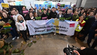Mit einem Transparent mit der Aufschrift: "Demokratie stärken - Kampf gegen Rechts!" demonstrieren Gegner der Partei AfD auf der Bildungsmesse Didacta vor dem Informationsstand der Partei. 