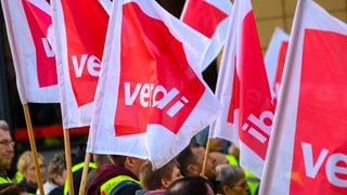 Streikende halten Flaggen der Gewerkschaft ver.di in die Luft. In Baden-Württemberg gibt es zahlreiche Warnstreiks im öffentlichen Dienst.