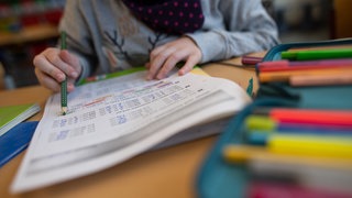 Ein Mädchen löst in einer Grundschule eine Matheaufgabe. (Symbolbild)