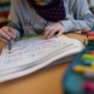 Ein Mädchen löst in einer Grundschule eine Matheaufgabe. (Symbolbild)