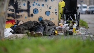 (Symbolbild) Eine Person liegt in der Innenstadt unter einem Schlafsack. Laut Liga der Freien Wohlfahrtspflege ist die Wohnungsnot in BW auf einem Höchststand.