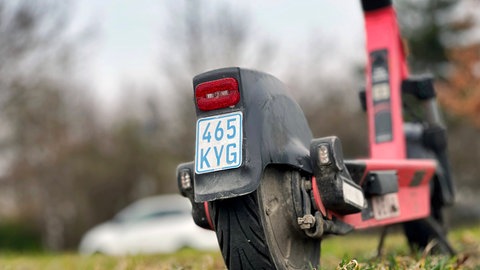 Ein blaues Versicherungskennzeichen eines E-Scooters, das ab März nicht mehr zulässig ist.