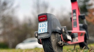 Ein blaues Versicherungskennzeichen eines E-Scooters, das ab März nicht mehr zulässig ist.
