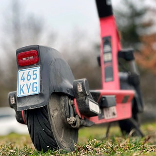 Ein blaues Versicherungskennzeichen eines E-Scooters, das ab März nicht mehr zulässig ist.