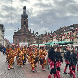 Verkleidete Menschen laufen am Schmutzigen Donnerstag zum Rathaussturm in Rastatt.