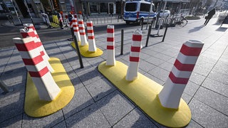 Mobile Poller sind an einer Zufahrtsstraße zum Schlossplatz zu sehen. In der baden-württembergischen Landeshauptstadt findet am 04. März ein großer Faschingsumzug statt.