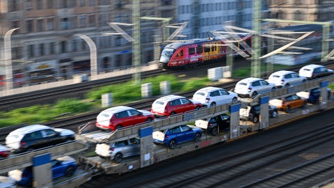Ein Güterzug transportiert Skoda Neuwagen durch einen Bahnhof in Dresden.