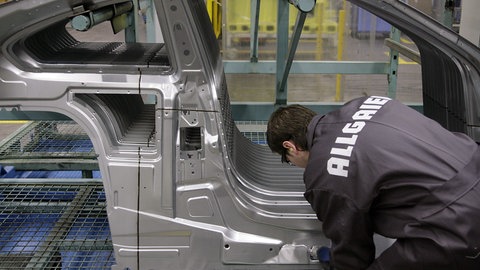 (Symbolbild) Ein Mitarbeiter der Allgaier Werke GmbH montiert im Werk in Uhingen (Baden-Württemberg) ein Karosserieseitenteil.