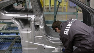 (Symbolbild) Ein Mitarbeiter der Allgaier Werke GmbH montiert im Werk in Uhingen (Baden-Württemberg) ein Karosserieseitenteil.