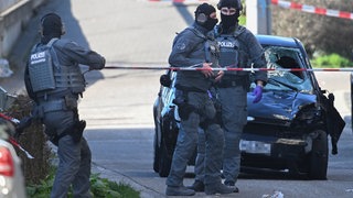 Polizeibeamte stehen vor einem beschädigten Auto: Der Innenausschuss beschäftigt sich noch nicht mit der Amokfahrt von Mannheim