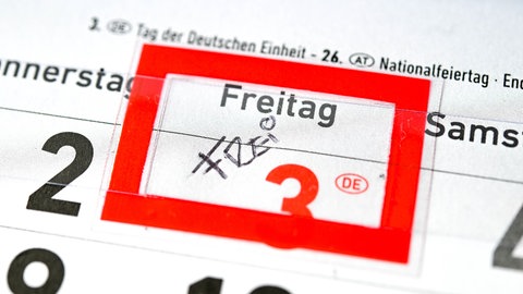 Ein Kalender liegt auf einem Tisch. Um die Wirtschaft anzukurbeln, wird unter anderem die Abschaffung eines Feiertages vorgeschlagen.