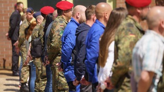 Bundeswehrsoldaten in Uniform stehen aufgerieht neben Zivilisten. BW will sich auf den Ernstfall vorbereiten.