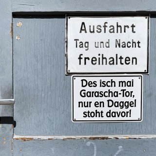 Ein Schild an einer Garage in Stuttgart. Die Landesregierung will sich für den Erhalt der Dialekte in Baden-Württemberg einsetzen.
