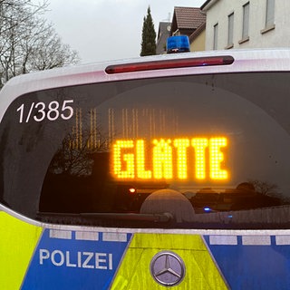 Ein Polizeiauto warnt mit einer "Glätte"-Anzeige vor Glatteis auf den Straßen in Ludwigsburg.