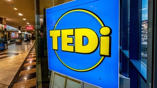 Das Logo des Discounters Tedi ist im Schaufenster einer Filiale angebracht.