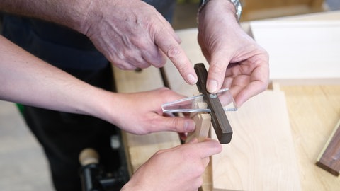 Auszubildende für Holztechnik arbeiten an einem Werkstück.