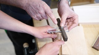 Auszubildende für Holztechnik arbeiten an einem Werkstück.