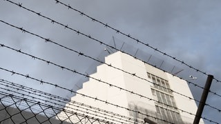 Das Gebäude der Justizvollzugsanstalt Stuttgart-Stammheim wird von einer Mauer mit einem Stacheldrahtzaun umschlossen. Bei einem Brand in einer Gefängniszelle an Ostern wurde eine Person schwer verletzt.