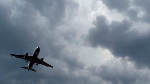 Maschine fliegt unter dunklen Wolken 