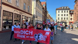 Menschen laufen anlässlich einer Demo zum 1. Mai durch die Heidelberger Innenstadt.