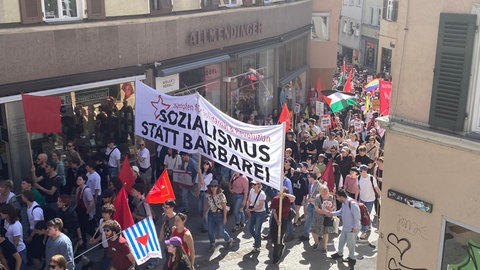 Demonstrantinnen und Demonstranten marschieren am 1. Mai durch die Innenstadt von Tübingen