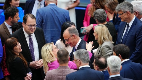 Im Bundestag gratulieren mehrere Leute dem neuen Kanzler Merz.