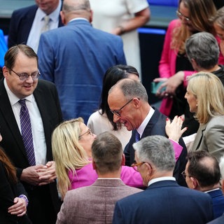 Im Bundestag gratulieren mehrere Leute dem neuen Kanzler Merz.