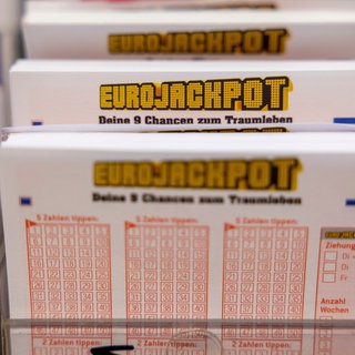 Eurojackpot Spielscheine stehen in einem Regal in einer Lotto-Annahmestelle.