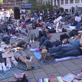 Menschen demonstrieren im Liegen in Stuttgart