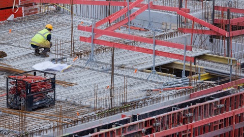 Bauarbeiter arbeiten an einem Rohbau für Eigentumswohnungen.