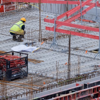 Bauarbeiter arbeiten an einem Rohbau für Eigentumswohnungen.
