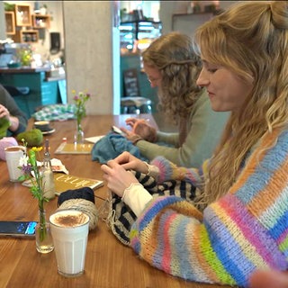 Eine Gruppe junger Frauen strickt gemeinsam